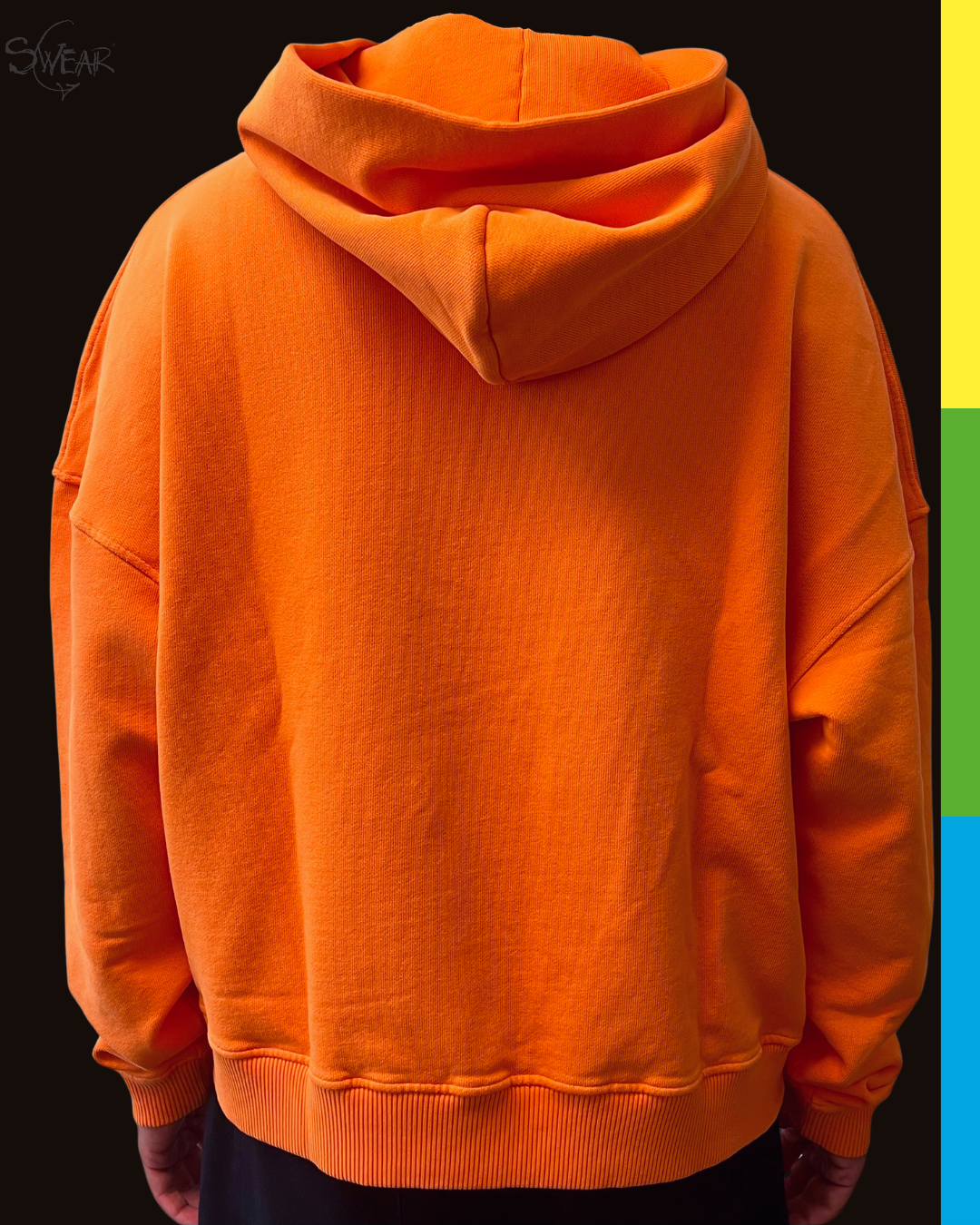 A bright orange pullover hoodie shown from the back, worn by a person against a dark background with a vertical multicolor stripe on the right side.