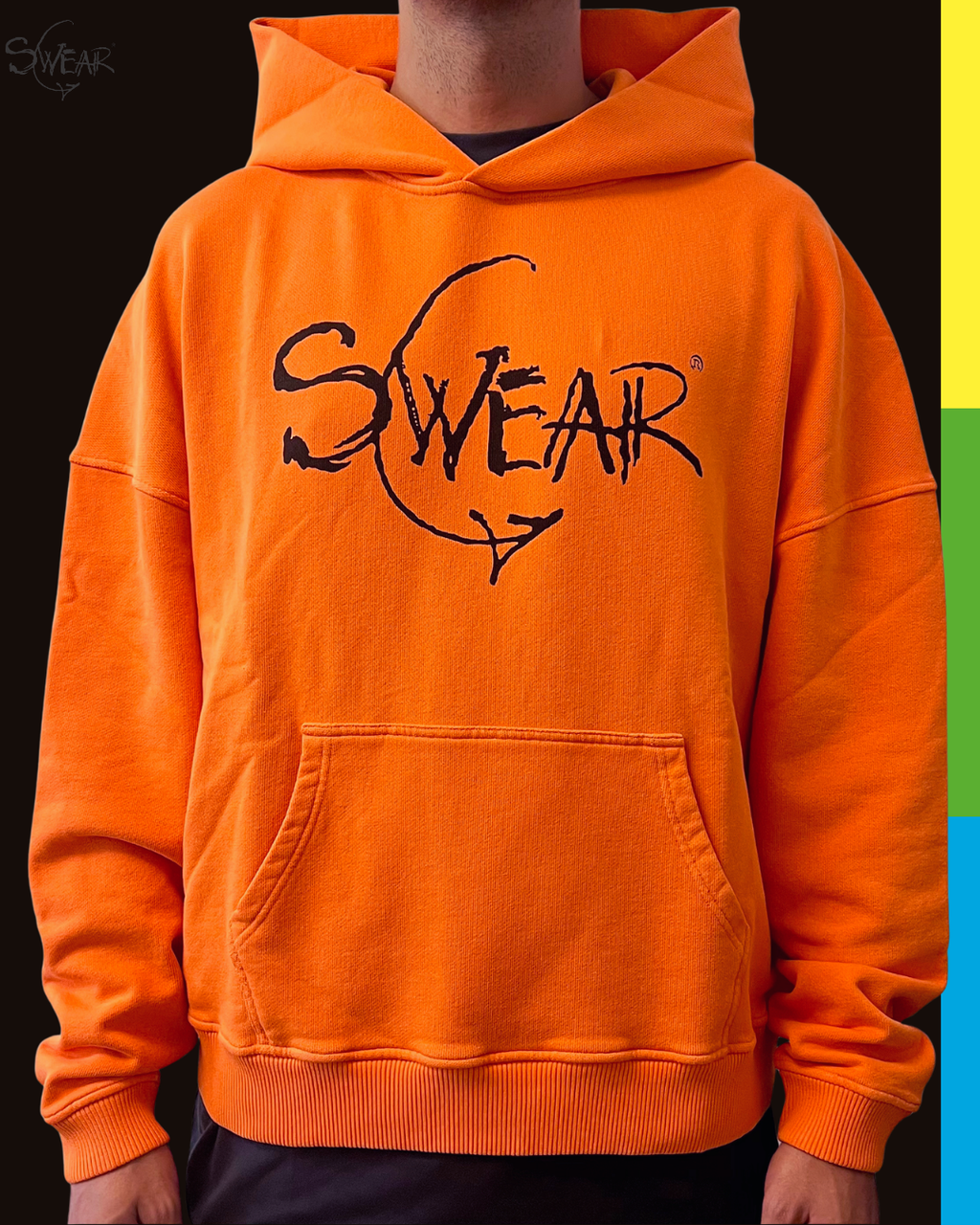 A person wearing a bright orange pullover hoodie with a black 'SWEAR' graphic across the chest, shown against a dark background with a vertical multicolor stripe on the right edge.