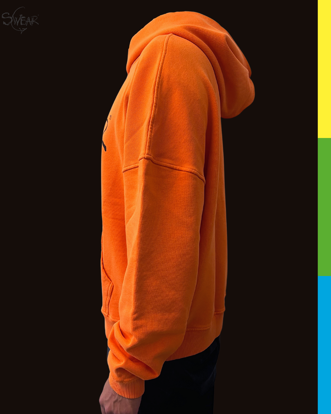 Side profile of a person wearing a bright orange pullover hoodie against a dark background, with a vertical color strip on the right side of the frame.