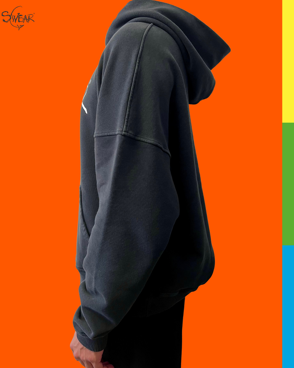 A person shown in side profile wearing an oversized dark charcoal hoodie against a bright orange background. A small white logo is visible on the upper left chest, and the wordmark 'SWEAR' appears in the top-left corner.